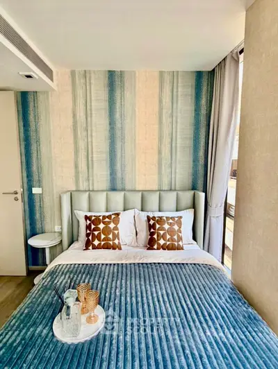 Stylish bedroom with modern decor and natural light, featuring a cozy bed and elegant accents.