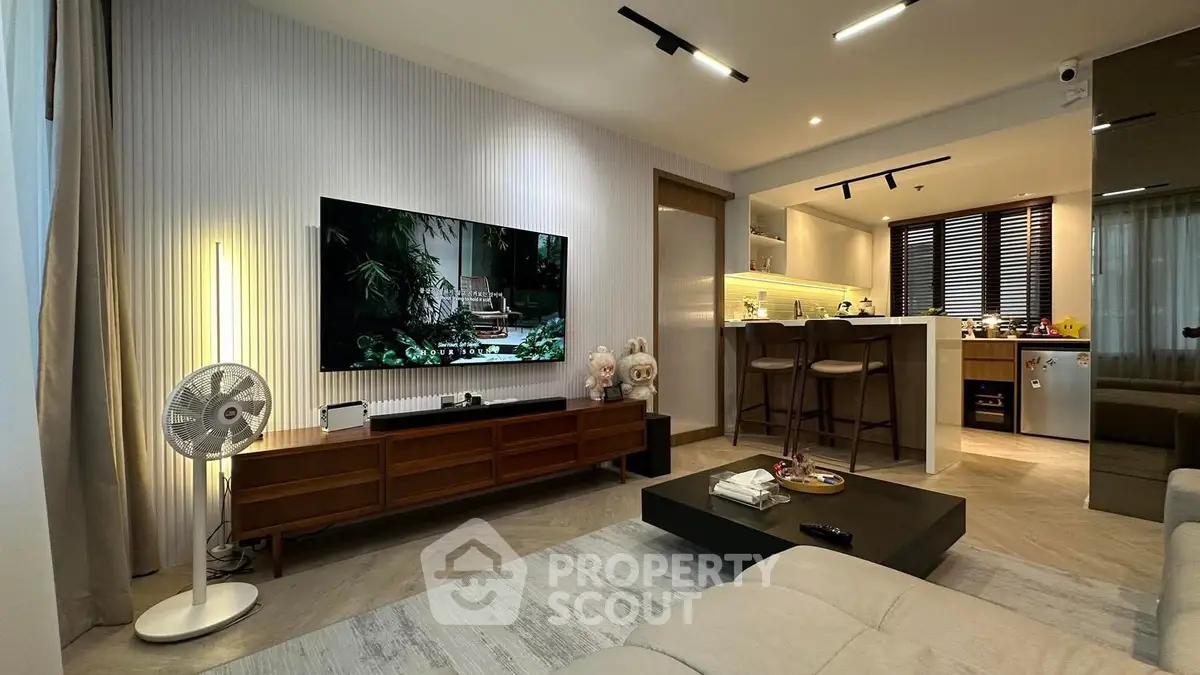 Modern living room with open kitchen, stylish decor, and cozy ambiance.