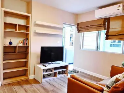 Modern living room with TV, shelves, and air conditioning in a cozy apartment.