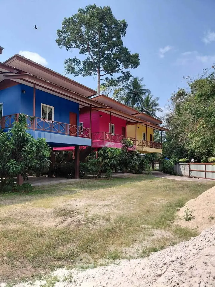 Vibrant multicolored exterior of a tropical residential building with lush greenery and spacious garden.