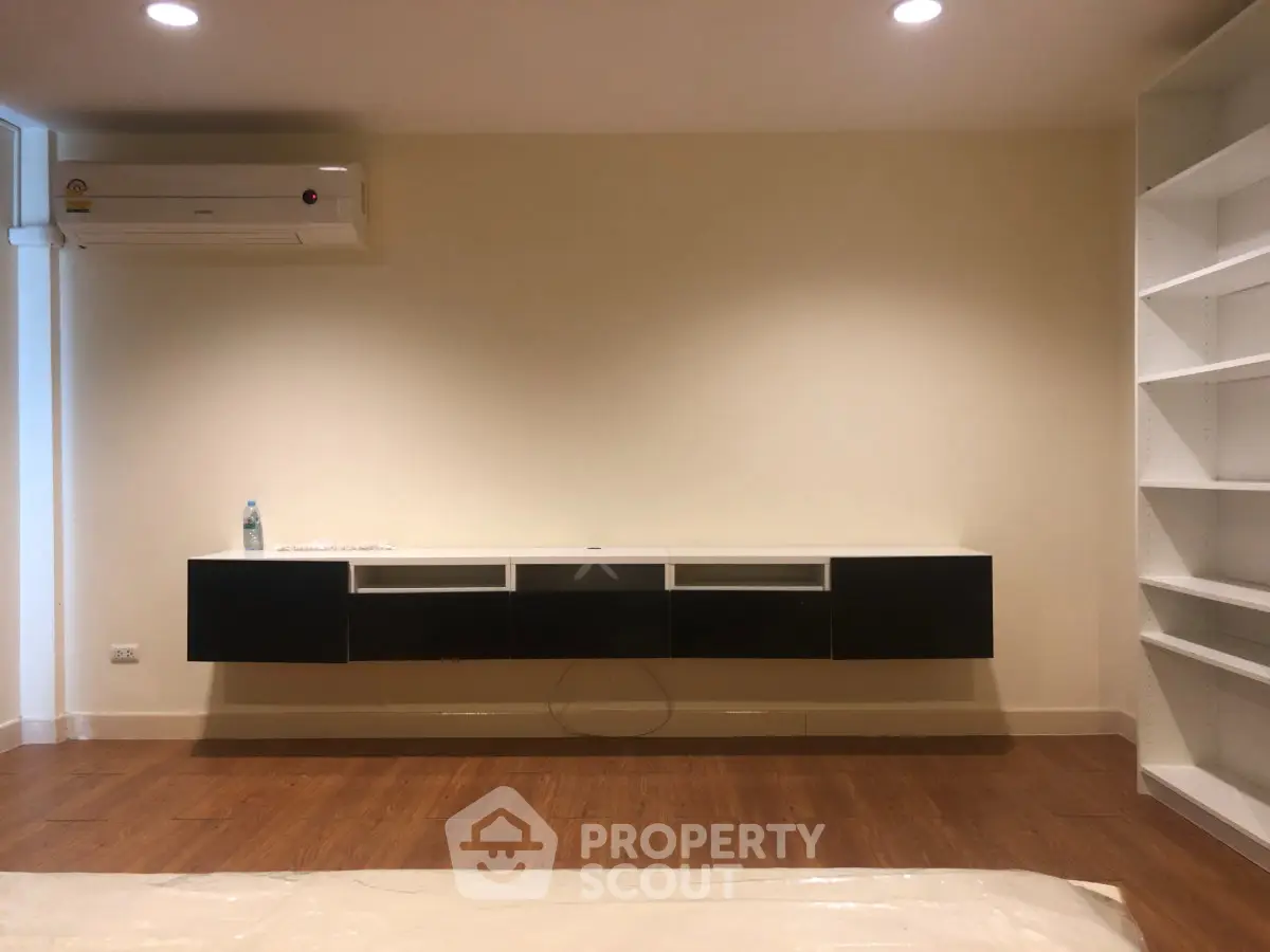 Modern living room with sleek wall-mounted cabinet and air conditioning unit.