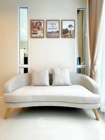 Stylish modern living room with elegant beige sofa and decorative wall art, perfect for cozy relaxation.