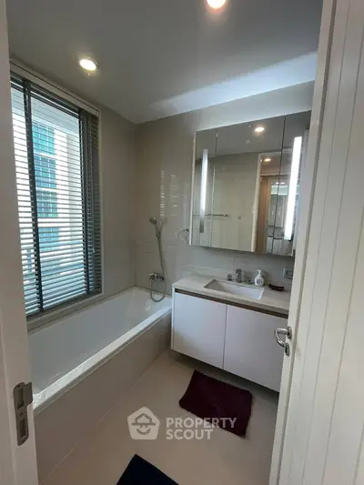 Modern bathroom with sleek design, featuring a bathtub and stylish vanity in a contemporary apartment.