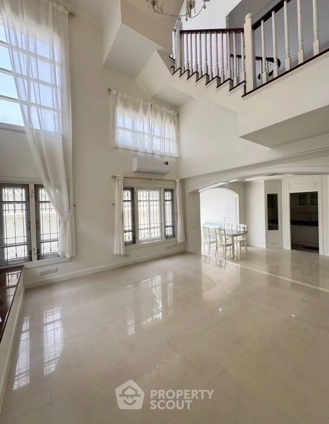 Spacious two-story living room with high ceilings and elegant staircase