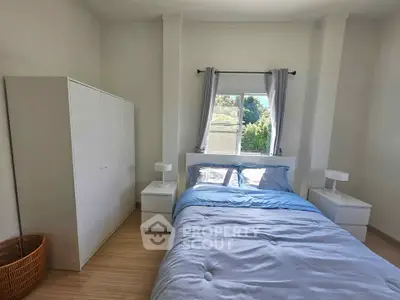 Cozy bedroom with natural light, featuring a comfortable bed and modern decor.