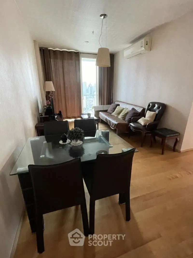 Cozy living room with dining area and city view, featuring modern furniture and air conditioning.