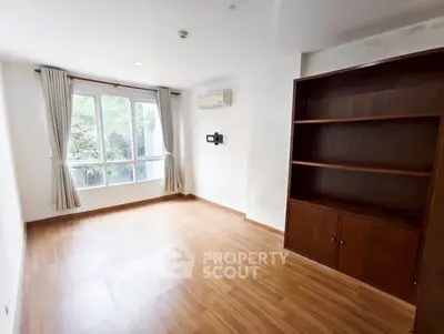 Spacious empty room with wooden flooring and large window view