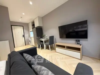 Modern living room with sleek furniture and wall-mounted TV in a stylish apartment.