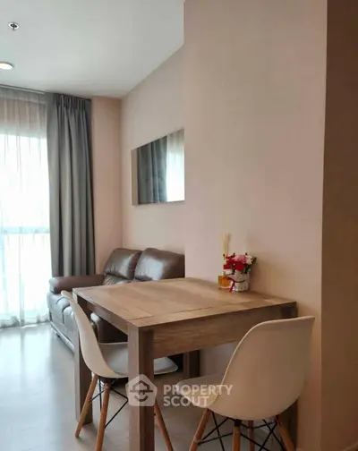 Modern living room with cozy seating and dining area, featuring natural light and stylish decor.