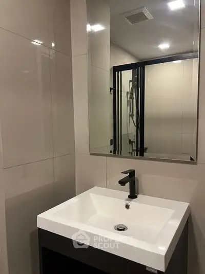 Modern bathroom with sleek sink and large mirror, perfect for contemporary living.