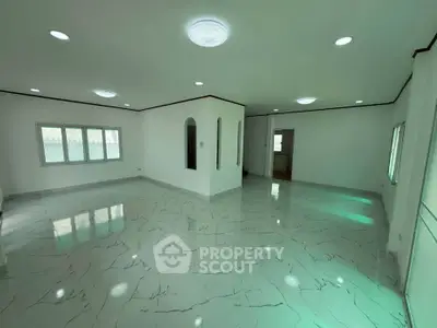 Spacious open-plan living area with elegant marble flooring and ample natural light.
