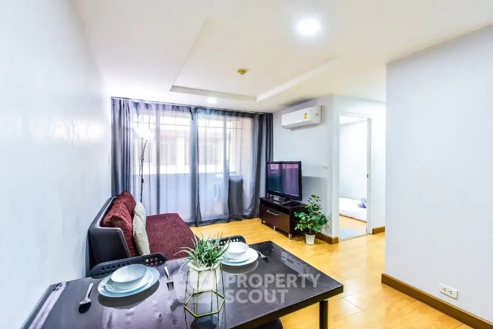 Modern living room with dining area, featuring stylish decor and natural light.