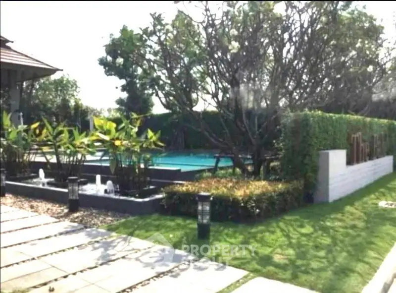 Luxurious garden with pool and lush greenery in a serene setting.
