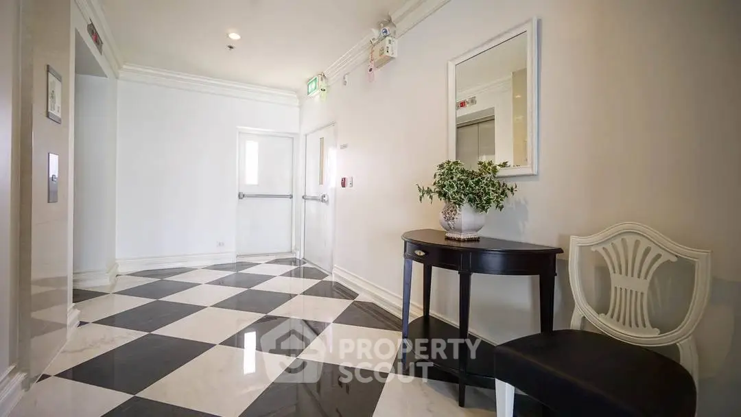 Elegant building entrance with black and white checkered floor and stylish decor.