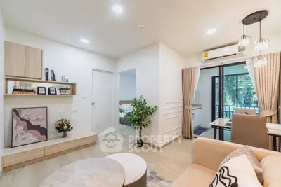 Modern living room with stylish decor and open layout leading to a balcony with a view.