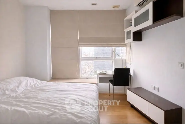 Modern minimalist bedroom with study area and large window view