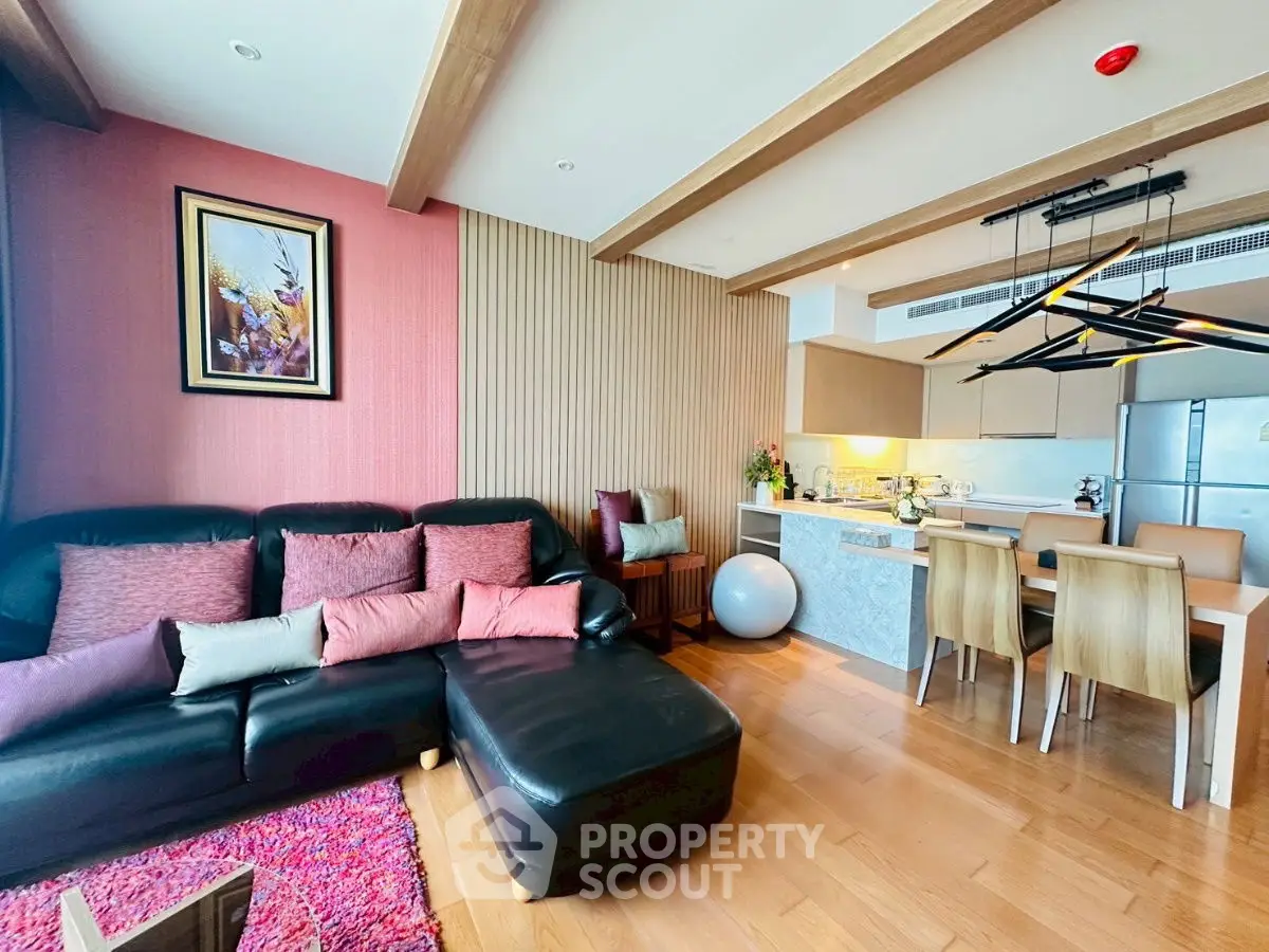 Modern living room with open kitchen, stylish decor, and cozy seating area.
