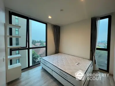 Spacious bedroom with large windows and scenic view in modern apartment