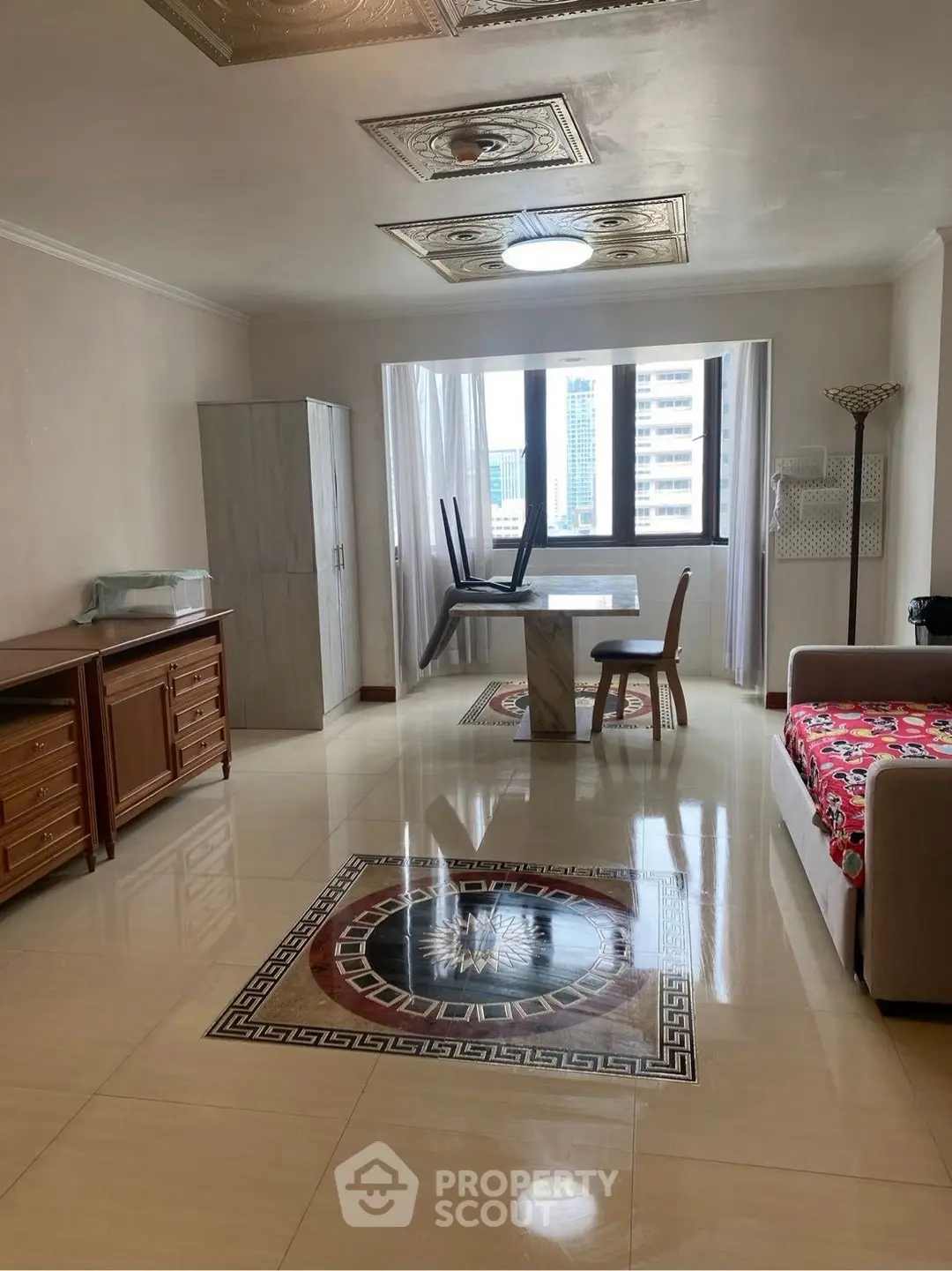 Spacious living room with elegant flooring and city view, featuring modern furniture and natural light.