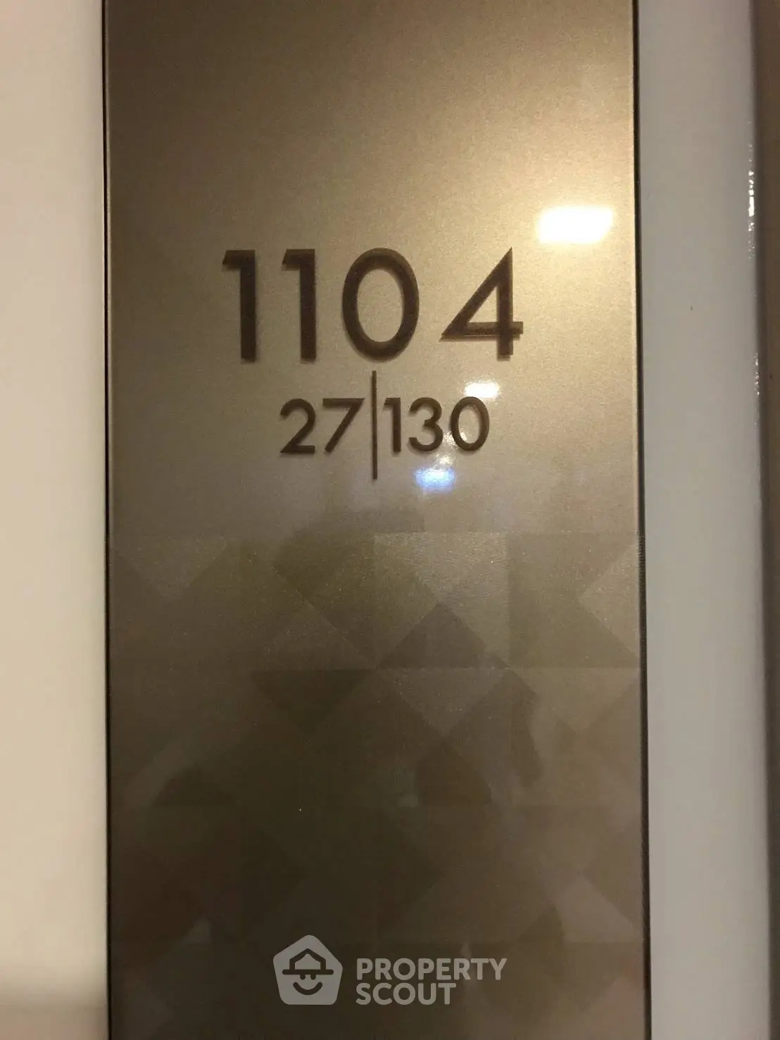 Modern apartment number plaque with geometric design, showcasing unit 1104 in a stylish building.