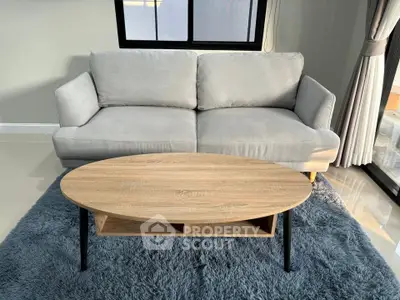 Modern living room with cozy gray sofa and stylish wooden coffee table on plush rug.