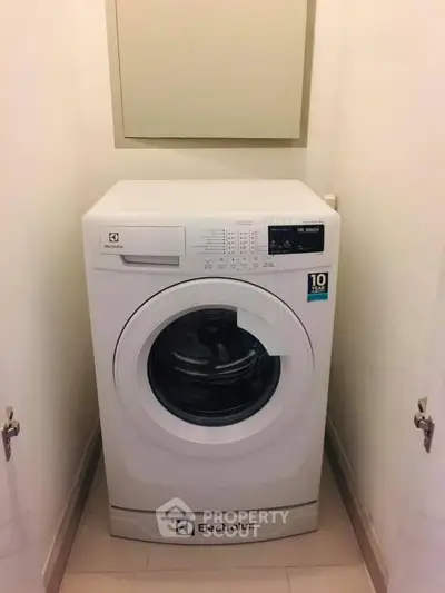 Compact laundry area featuring Electrolux washing machine in a modern home.
