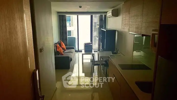 Modern apartment interior with sleek kitchen and cozy living area, featuring large windows and stylish decor.