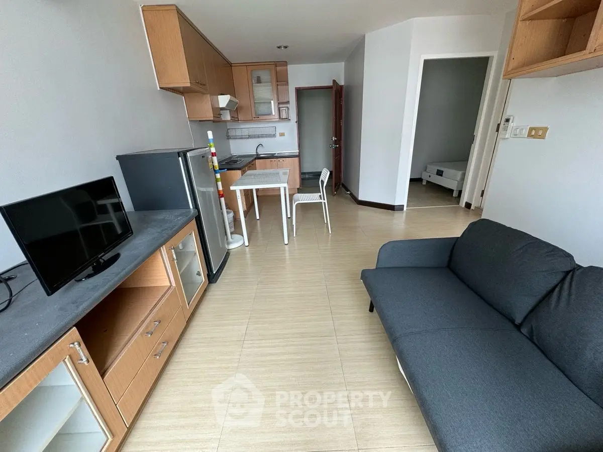 Modern apartment living room with sleek furniture and open kitchen layout.