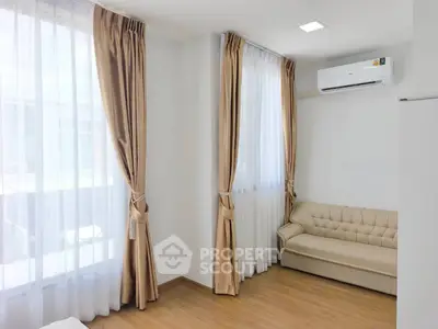 Bright living room with elegant curtains and cozy sofa, featuring modern air conditioning.