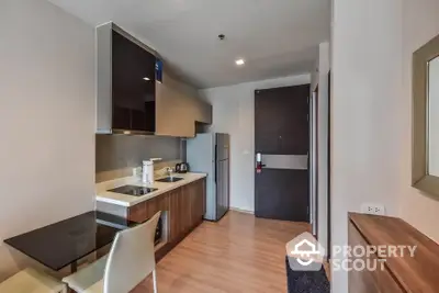 Modern kitchen with sleek cabinetry and dining area in stylish apartment