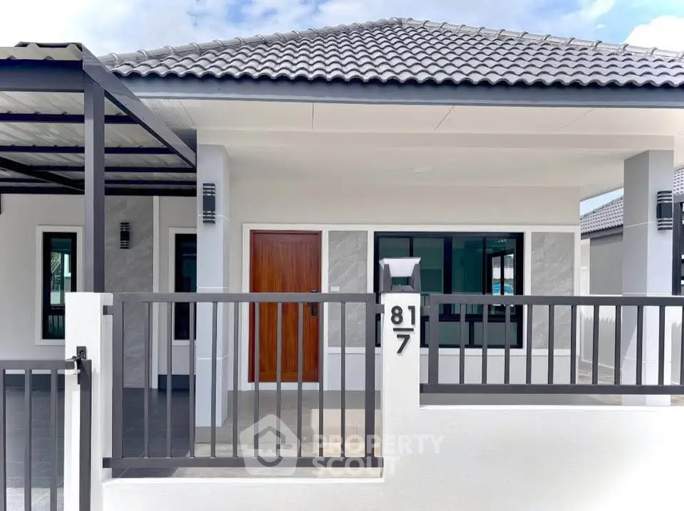 Modern single-story house with tiled roof and gated entrance