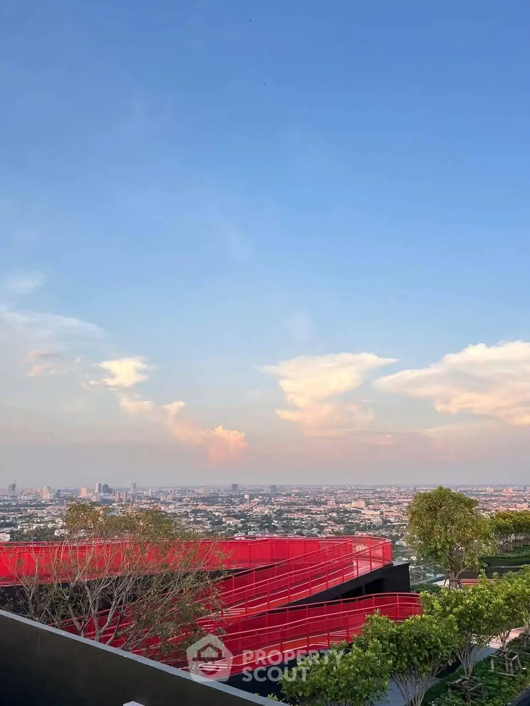 Stunning rooftop view with vibrant red architectural elements and expansive cityscape.