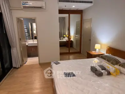Spacious bedroom with mirrored closet and ensuite bathroom in modern apartment
