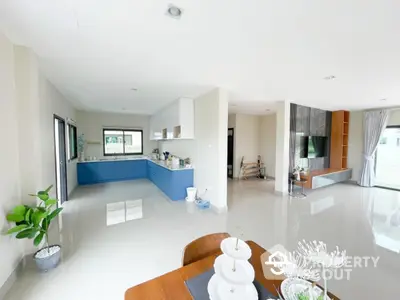 Spacious modern open-plan living room and kitchen with sleek design and natural light.