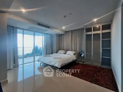 Spacious modern bedroom with balcony and glass wardrobe in luxury apartment