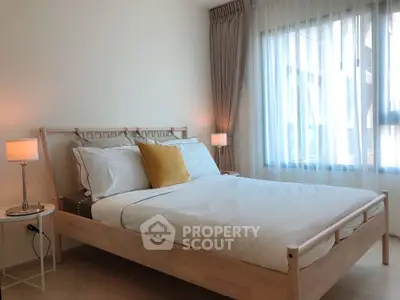 Bright and cozy bedroom with modern decor and large window for natural light.