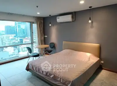 Modern bedroom with city view, featuring a cozy bed, stylish lighting, and a small dining area.