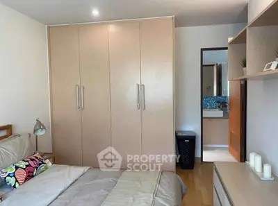 Cozy bedroom with built-in wardrobe and modern decor, perfect for comfortable living.