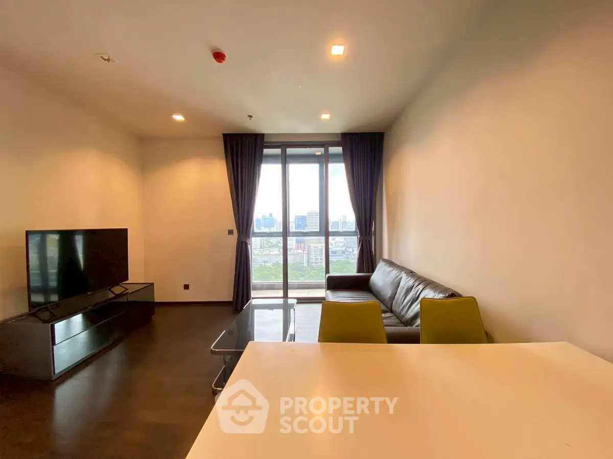 Spacious modern living room with city view, featuring sleek furniture and large windows for natural light.