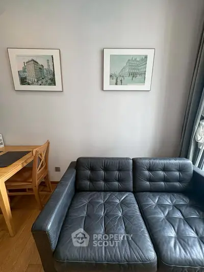 Stylish living room with black leather sofa and elegant wall art, perfect for modern urban living.