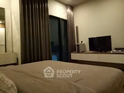 Cozy bedroom with modern decor and large window offering city view.