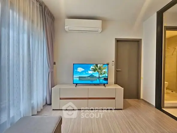 Modern living room with air conditioning and sleek TV setup, perfect for relaxation.