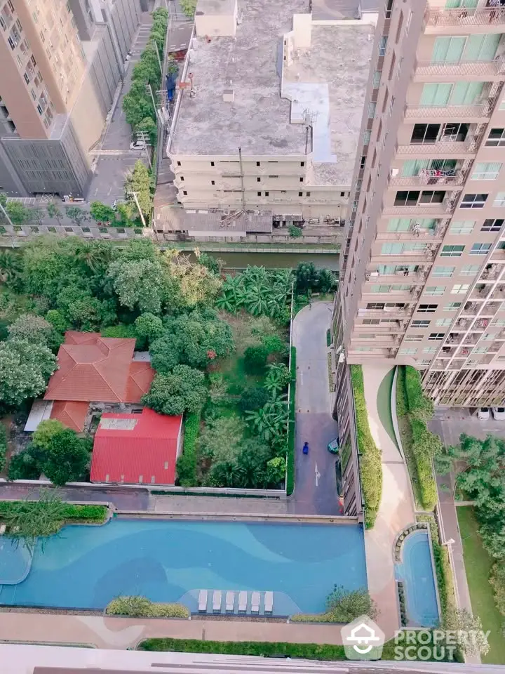 Stunning aerial view of modern condominium with lush garden and inviting swimming pool