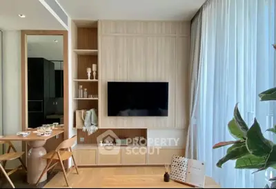 Modern living room with stylish decor and large TV, featuring elegant dining area and natural light.