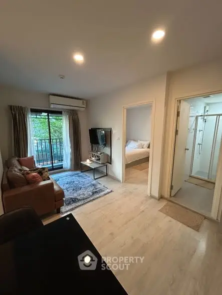 Modern apartment interior with cozy living room, bedroom, and balcony view.