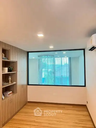 Modern living room with large window and wooden flooring