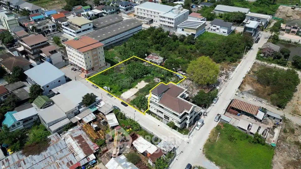 Aerial view of a potential real estate development site outlined in yellow, surrounded by urban buildings.