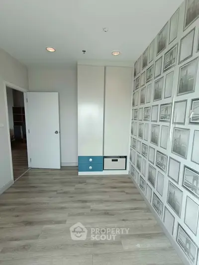 Modern bedroom with stylish wallpaper and built-in wardrobe, featuring sleek wood flooring.