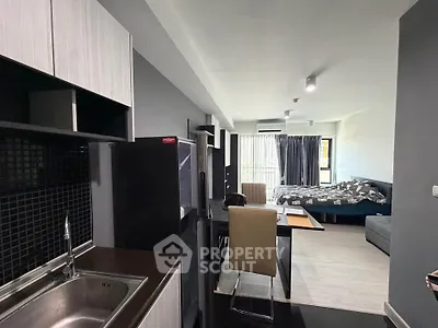 Modern studio apartment with open layout, featuring sleek kitchen and cozy living area with natural light.