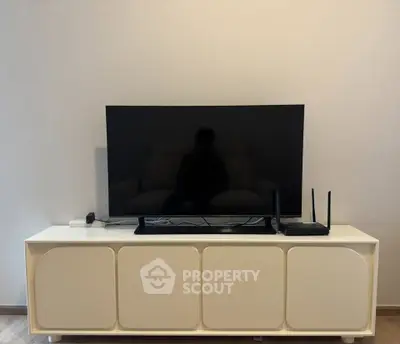Modern living room with sleek TV setup on stylish white console.